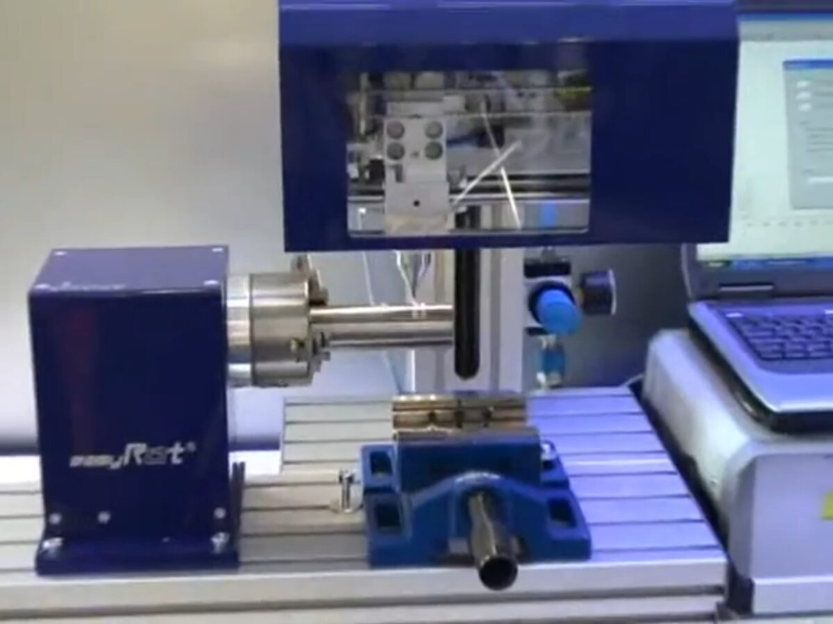 Znakowarka mikropunktowa Easy Marker podczas pracy na stanowisku z obrotowym uchwytem i imadłem.