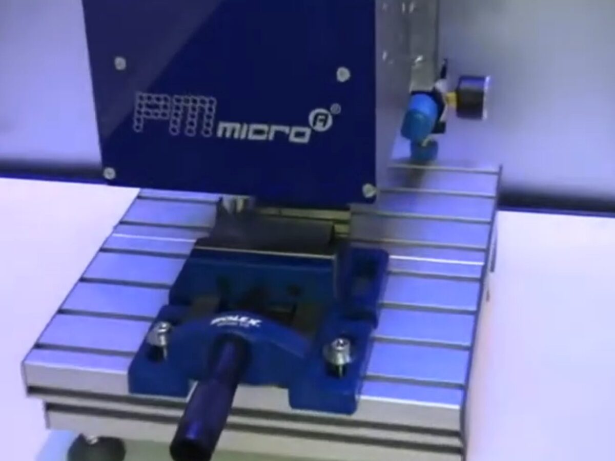 Głowica znakowarki mikropunktowej PMmicroA podczas pracy na stanowisku z imadłem.