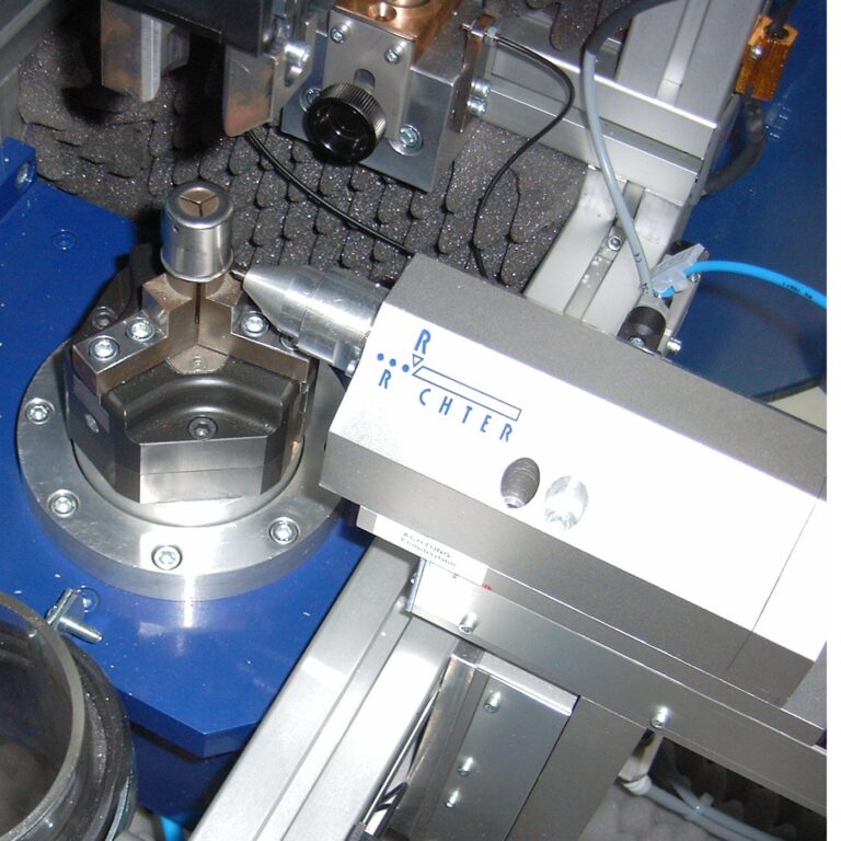 Znakowarka mikropunktowa Unigrav podczas pracy na obrotowym uchwycie do detali metalowych.