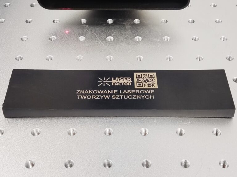 Laserowe znakowanie tworzyw sztucznych z logo Laser Factor i kodem 2D.